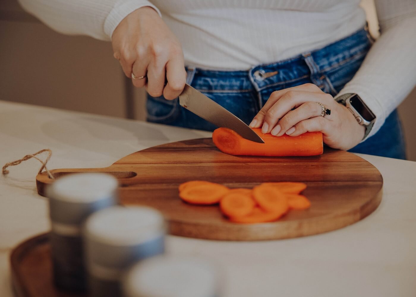 Karotte wird auf einem Schneidebrett geschnitten – Zubereitung ayurvedischer Gerichte mit Kapha Gewürzmischung.