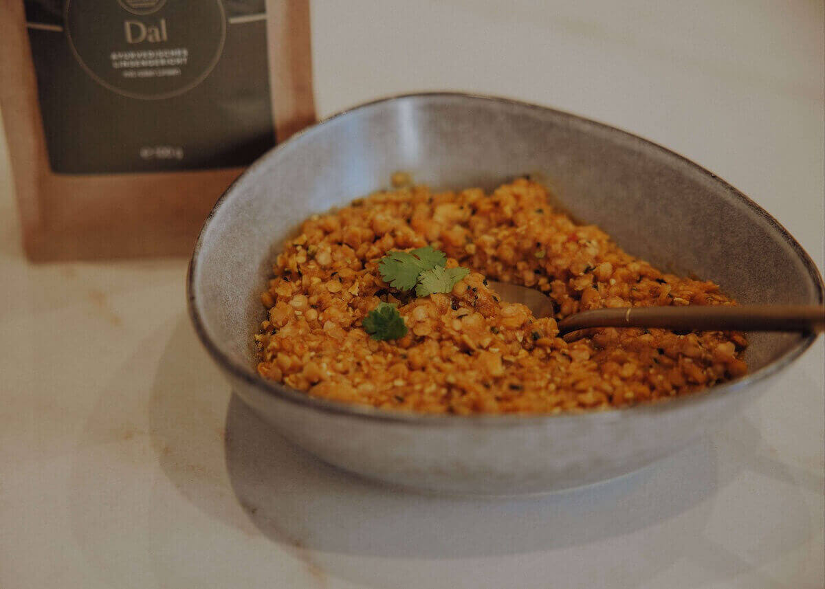 Das ayurvedische Dal mit roten Linsen in einer Schale angerichtet.